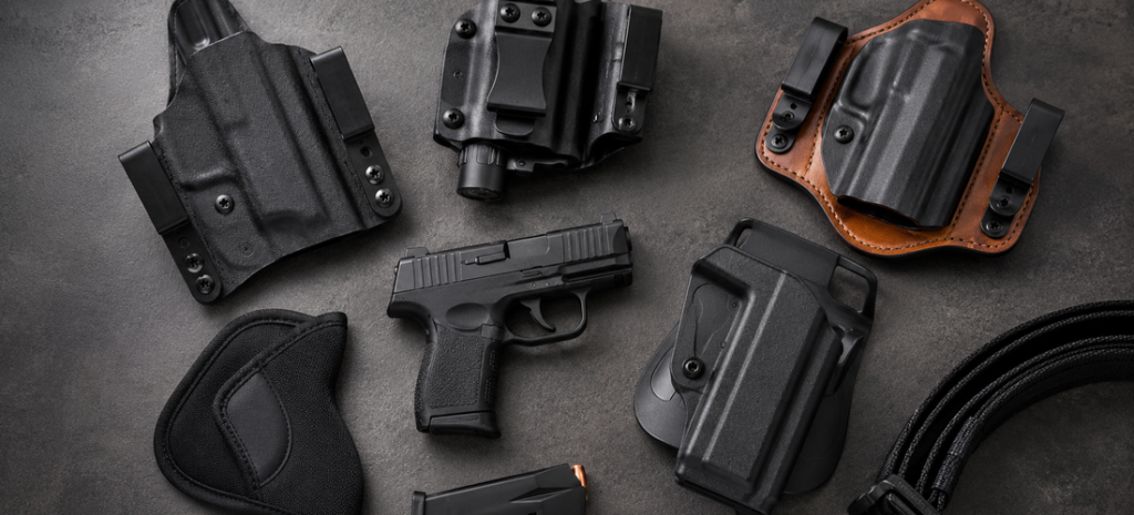 Sig P365 pistol with IWB, OWB, appendix, pocket, and hybrid holsters arranged on a dark tabletop.