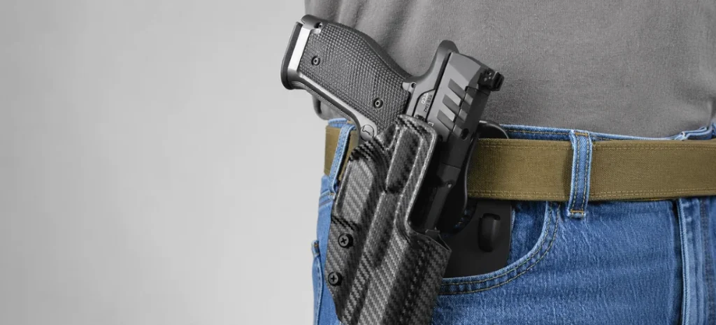 Handgun secured in a carbon-fiber OWB holster.