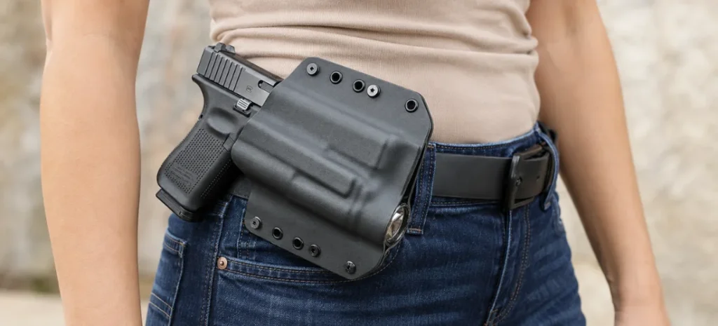 Woman wearing a handgun in a gray molded OWB holster.
